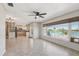 Open living room featuring tile floors, ceiling fan, and a large window overlooking the outdoor waterfront view at 1717 Danbury Dr, Sun City Center, FL 33573