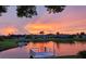 Picturesque sunset view over the tranquil water, featuring a private dock and lush surroundings at 1717 Danbury Dr, Sun City Center, FL 33573