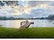 Picturesque lake view featuring a wooden dock extending into calm waters with a scenic, cloudy sky at 1821 Weekend Ln, Odessa, FL 33556