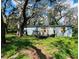 A charming light-blue single-story home nestled among mature trees, offering a tranquil setting and appealing curb appeal at 1821 Weekend Ln, Odessa, FL 33556