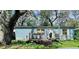 Charming single-story home features a welcoming porch, set among mature trees in its front yard at 1821 Weekend Ln, Odessa, FL 33556