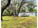 Quaint home featuring a front deck, surrounded by a green lawn and mature trees, creating a serene setting at 1821 Weekend Ln, Odessa, FL 33556