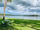 Scenic lake view with a shaded picnic area featuring lush green grass and beautiful skies; perfect for relaxation and outdoor enjoyment at 1821 Weekend Ln, Odessa, FL 33556