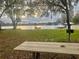 Scenic waterfront view with a wooden picnic table and dock, perfect for relaxing by the serene lake at 1821 Weekend Ln, Odessa, FL 33556
