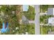 An aerial view showcases a charming Bradenton home nestled between lush trees and its proximity to a street at 1826 2Nd E Ave, Bradenton, FL 34208