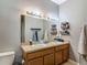 Well-lit bathroom with double sinks, vanity, and storage shelves at 18339 Fish Loop, Land O Lakes, FL 34638