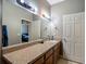 Bathroom featuring a long vanity, a large mirror, neutral walls, and a door to a bedroom at 18339 Fish Loop, Land O Lakes, FL 34638