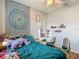 Bright bedroom with a mandala tapestry, ceiling fan, desk, and wood-look flooring at 18339 Fish Loop, Land O Lakes, FL 34638