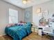 Charming bedroom with a tapestry, a desk, wood-look flooring, and a ceiling fan at 18339 Fish Loop, Land O Lakes, FL 34638