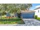 Charming single-Gathering home with a blue exterior, a well-manicured lawn, and an attached two-car garage at 18339 Fish Loop, Land O Lakes, FL 34638