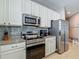 Modern kitchen featuring white cabinets, stainless steel appliances, granite countertops, and tile backsplash at 18339 Fish Loop, Land O Lakes, FL 34638