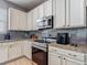Modern kitchen featuring white cabinets, stainless steel appliances, granite countertops, and tile backsplash at 18339 Fish Loop, Land O Lakes, FL 34638
