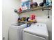 Laundry room with modern washer and dryer, white walls, and shelving at 18339 Fish Loop, Land O Lakes, FL 34638