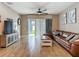 Spacious living room features wood-look tile, ceiling fan, and sliding door access to the outdoor area at 18339 Fish Loop, Land O Lakes, FL 34638