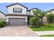 Charming two-story home showcasing a brick driveway, a two-car garage, and well-manicured landscaping at 19259 Mossy Pine Dr, Tampa, FL 33647