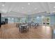 Bright community meeting room with light blue walls, tray ceilings, and neutral wood flooring at 19259 Mossy Pine Dr, Tampa, FL 33647