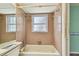 A bathroom featuring a tub/shower combo with tiled walls and a window at 1972 Lansing Dr, Clearwater, FL 33763