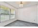 Empty carpeted room featuring natural light from a window and an ornate ceiling light at 1972 Lansing Dr, Clearwater, FL 33763