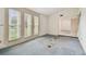 Bright living room featuring natural light from a large window and old, stained carpet at 1972 Lansing Dr, Clearwater, FL 33763