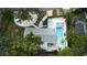 Aerial view of a house featuring a backyard pool, patio, and fire pit, surrounded by green trees and a landscaped yard at 201 South St, Palm Harbor, FL 34683