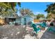 Bright backyard area with pool, patio, perimeter fence, comfortable seating, and mature landscaping at 201 South St, Palm Harbor, FL 34683