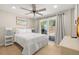 Bright bedroom with hardwood floors, backyard views and access, neutral walls, and white bedding at 201 South St, Palm Harbor, FL 34683
