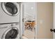 Functional laundry area with stacked washer and dryer, with easy access to kitchen and dining area at 201 South St, Palm Harbor, FL 34683