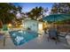 Outdoor pool area with dining, lush landscaping, and comfortable seating; perfect for Florida outdoor living at 201 South St, Palm Harbor, FL 34683