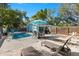 Inviting pool area with dining, sun loungers, perimeter fence, and comfortable seating at 201 South St, Palm Harbor, FL 34683