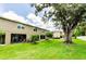 Large backyard with mature landscaping, green grass, and screened patio, providing an ideal space to relax at 2119 Broadway View Ave, Brandon, FL 33510