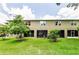 Home's backyard with green grass, mature landscaping, and screened-in patio, perfect for relaxing at 2119 Broadway View Ave, Brandon, FL 33510