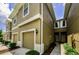 Close-up perspective of townhome exteriors showing garages, entryways, and manicured shrubs at 2119 Broadway View Ave, Brandon, FL 33510