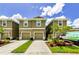 Attractive townhome exteriors displaying lush lawns, colorful flower beds, and convenient driveways at 2119 Broadway View Ave, Brandon, FL 33510
