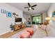 Comfortable living room has a ceiling fan, wood flooring, and a sliding glass door to the backyard at 2119 Broadway View Ave, Brandon, FL 33510