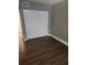 Bedroom featuring modern dark wood-look floors and a closet with bi-fold doors at 2209 Belleair Rd # C3, Clearwater, FL 33764