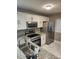 Updated kitchen featuring white cabinets, stainless steel appliances, and granite countertops at 2209 Belleair Rd # C3, Clearwater, FL 33764
