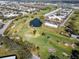 An aerial view of a community near a golf course with mature trees, lush greenery and a tranquil pond at 2222 Norwegian Dr # 16, Clearwater, FL 33763