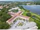 Aerial view of a lakeside apartment complex surrounded by lush greenery and ample parking at 2222 Norwegian Dr # 16, Clearwater, FL 33763