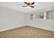 Bright bedroom with ceiling fan, light walls, and a large window offering outdoor views at 2222 Norwegian Dr # 16, Clearwater, FL 33763