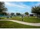 Community picnic area, with tables, umbrellas, and charcoal grills; tennis courts can be seen in the background at 2222 Norwegian Dr # 16, Clearwater, FL 33763