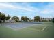 Well-maintained tennis courts with a community building and lush landscaping in the background at 2222 Norwegian Dr # 16, Clearwater, FL 33763
