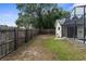 A fenced backyard featuring a grassy area, partial view of the house, and screened-in pool enclosure at 2319 Canfield Dr, Spring Hill, FL 34609