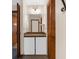 Bathroom vanity with white cabinets, brown tile countertop and a dark wood door at 2319 Canfield Dr, Spring Hill, FL 34609