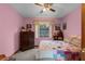 A cozy bedroom features pink walls, carpeting, and a bright, colorful quilt at 2319 Canfield Dr, Spring Hill, FL 34609