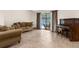 Cozy living area with a comfortable sofa, an upright piano, and sliding glass doors to the pool area at 2319 Canfield Dr, Spring Hill, FL 34609