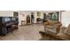 Open living room with tile floors, comfortable seating, and a view of the dining and kitchen areas at 2319 Canfield Dr, Spring Hill, FL 34609