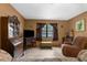 Welcoming living room with brown walls, wood furniture, tile floors, and a cozy recliner at 2319 Canfield Dr, Spring Hill, FL 34609