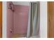 A classic, tiled shower with pink tiles and gray shower curtain at 2319 Canfield Dr, Spring Hill, FL 34609