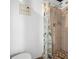 Bathroom with a shower featuring light tile, a tiled floor, and a charming curtain at 2353 Eastwood Dr, Clearwater, FL 33765