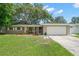 Charming single-story home with a well-manicured lawn, mature trees, and an attached two-car garage at 2353 Eastwood Dr, Clearwater, FL 33765